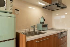 a kitchen with a sink and a microwave at La Classe Angel Road 2 - Vacation STAY 71507v in Fuchisaki