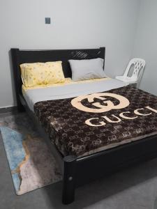 a bed in a room with a black bed frame at Ella Apartment Albert Cook Road in Kampala