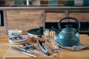 a table with a tea kettle and utensils on it at 城崎温泉一棟貸しの宿　ゆっ蔵 in Toyooka