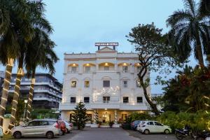 un edificio blanco con un letrero de la calle encima en Hotel Narendra Central, en Mūvattupula