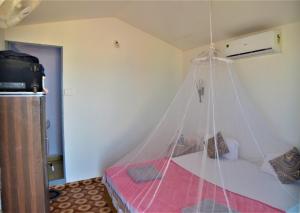 1 dormitorio con 1 cama con mosquitera en Agonda Sun Set, en Agonda