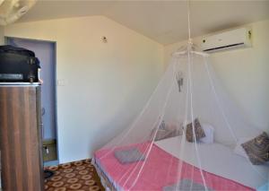 a bedroom with a bed with a mosquito net at Agonda Sunset Beach Resort in Agonda