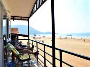 kobieta siedząca na krześle patrząca na plażę w obiekcie Agonda Sun Set w mieście Agonda