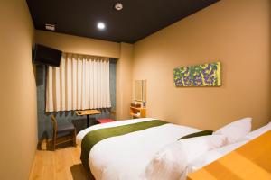 a hotel room with two beds and a window at Ryokan Suzuran Tengachaya in Osaka