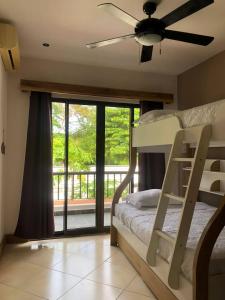Full condo in Tamarindo, CR في تاماريندو: غرفة نوم مع سرير بطابقين وشرفة