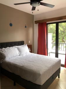 um quarto com uma cama e uma ventoinha de tecto em Full condo in Tamarindo, CR em Tamarindo