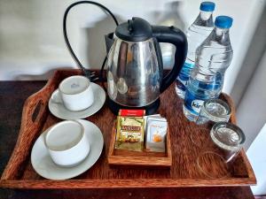 bandeja de madera con tetera y tazas en una mesa en Sweden Inn Guesthouse en Hikkaduwa