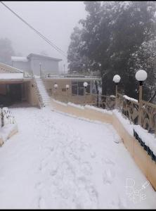 uma rua coberta de neve em frente a um edifício em Rashk e Qamar em Murree