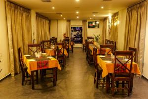 un restaurante con mesas y sillas con mantel amarillo en Hotel Narendra Central, en Mūvattupula