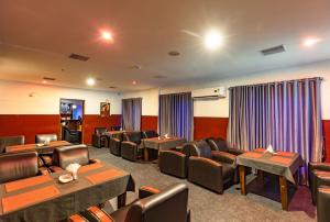 una sala de espera con mesas y sillas en un hotel en Hotel Narendra Central, en Mūvattupula