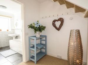 a bathroom with a blue shelf with a heart on the wall at 27 Cae Du in Abersoch +30 photos