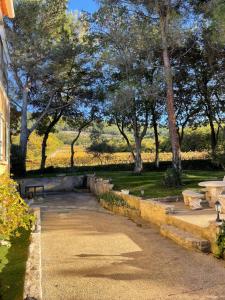 een park met een bank en bomen op de achtergrond bij Entre vignes et horizon Appartement avec jacuzzi privatif et piscine commune chauffée in Sablet