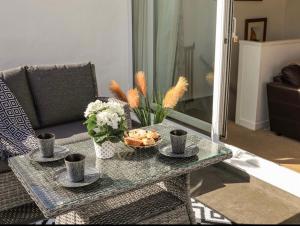 una sala de estar con una mesa con copas y flores en 27 Cae Du, en Abersoch