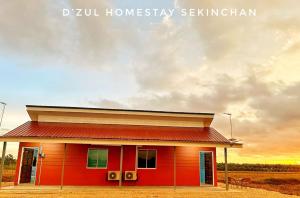 una pequeña casa roja con un cielo nublado detrás de ella en 3-4paxs Sekinchan Dzulhomestasy Padi View Aircon, en Kampong Batu Dua Puloh Tiga