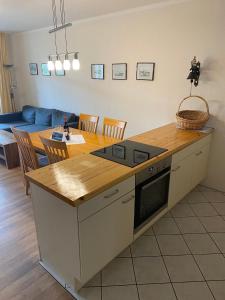 a kitchen and living room with a table and a couch at Haus Strandeck Apartment Meeresrauschen 10 in Göhren