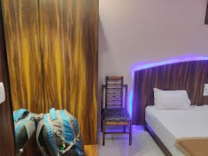 a bedroom with a bed and a chair in a room at Hotel Aaradhya International Jagdalpur in Jagdalpur