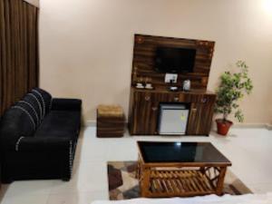 a living room with a couch and a coffee table at Hotel Aaradhya International Jagdalpur in Jagdalpur