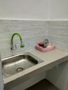 un lavandino della cucina con rubinetto verde su un bancone di Mando Homestay II a Bukittinggi