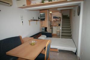 una pequeña sala de estar con una mesa y una cama en Apartment Ana, en Crikvenica