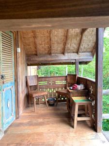 a porch of a house with two chairs and a table at Villa Kepuh in Singaraja