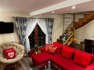 a living room with a red couch and a chair at Zyngierka in Bańska