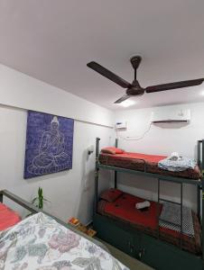 a room with two bunk beds and a ceiling fan at Hippie Paws in Mandrem