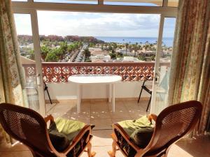 Pokój z 2 krzesłami i dużym oknem w obiekcie Tenerife Flamingo w mieście Palm-Mar