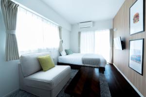 ein Hotelzimmer mit einem Bett und einem Stuhl in der Unterkunft BREAKY HOTEL west coast in Urazoe