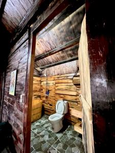 a bathroom with a toilet in a wooden wall at Mando Homestay in Bắc Yên