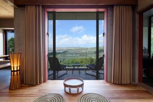 a living room with a large glass door with a view at Kaiza in Nanjo