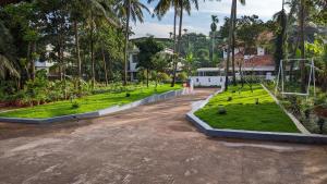 an empty parking lot with a park with palm trees at HILL TOP HOMES in Kannur