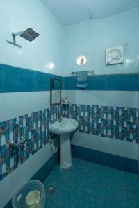 a bathroom with a sink and a mirror at Corbett Madhavi Homestay in Belparāo