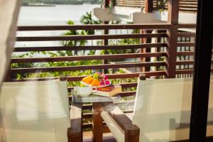 a table with a bowl of fruit on a balcony at Nghê Prana Villa & Spa Hoi An in Hoi An