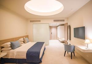 a hotel room with a bed and a flat screen tv at SENTIDO Reef Oasis Suakin Resort in Marsa Alam City