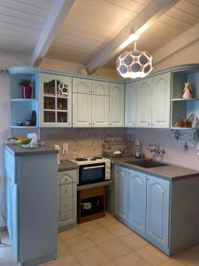 a kitchen with blue cabinets and a stove top oven at Cottage house with incredible view in Trápeza