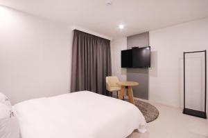 a hotel room with a bed and a television at XYM Hotel Mundeok in Pohang