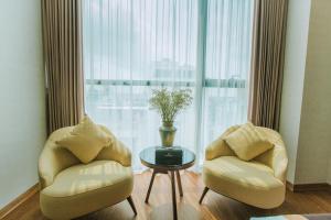 duas cadeiras e uma mesa em frente a uma grande janela em Luxury6 Hotel em Móng Cái