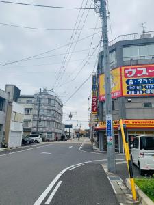 une rue de la ville avec une voiture blanche garée devant un bâtiment dans l'établissement Ogaki Hiyori Hotel - Vacation STAY 72007v, à Ōgaki