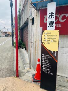 un panneau sur le côté d'une rue avec un cône de circulation dans l'établissement Ogaki Hiyori Hotel - Vacation STAY 72007v, à Ōgaki