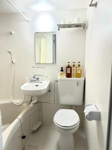 La salle de bains blanche est pourvue de toilettes et d'un lavabo. dans l'établissement Ogaki Hiyori Hotel - Vacation STAY 72007v, à Ōgaki