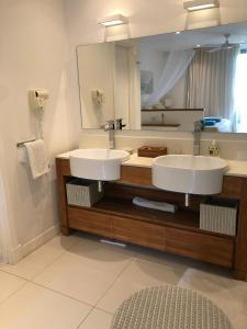 リヴィエール・ノワールにある2 bedrooms charming apartment, West Island Resortのバスルーム(シンク2台、大きな鏡付)