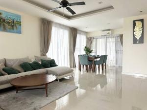 a living room with a couch and a table at Friendly Townhouse Laguna Park in Thalang