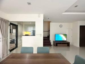 a living room with a dining table and a television at Friendly Townhouse Laguna Park in Thalang