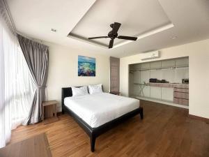 a bedroom with a bed and a ceiling fan at Friendly Townhouse Laguna Park in Thalang