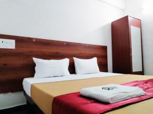 a bedroom with a large bed with a wooden headboard at Hotel Royal Green Inn in Chennai