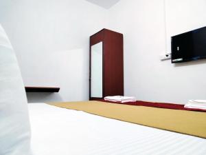 Habitación con cama con espejo y TV. en Hotel Royal Green Inn en Chennai