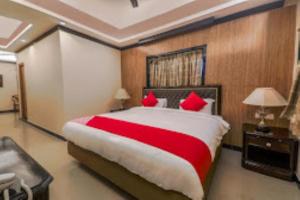 um quarto com uma cama grande e almofadas vermelhas em Airport Guest House Guwahati em Guwahati