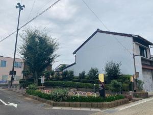 un bâtiment blanc avec un panneau devant lui dans l'établissement Ogaki Hiyori Hotel - Vacation STAY 98777v, à Ōgaki