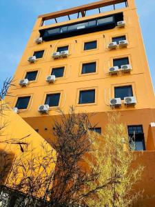 un edificio alto de color amarillo con aire acondicionado en Ogaki Hiyori Hotel - Vacation STAY 90787v en Ogaki
