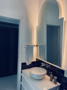 een badkamer met een witte wastafel en een spiegel bij Casa Torre a Sorrento con parcheggio gratuito in Sorrento